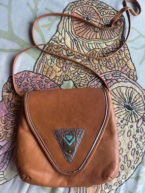Vintage Distressed Pat Smiley leather crossbody bag with triangular accent.